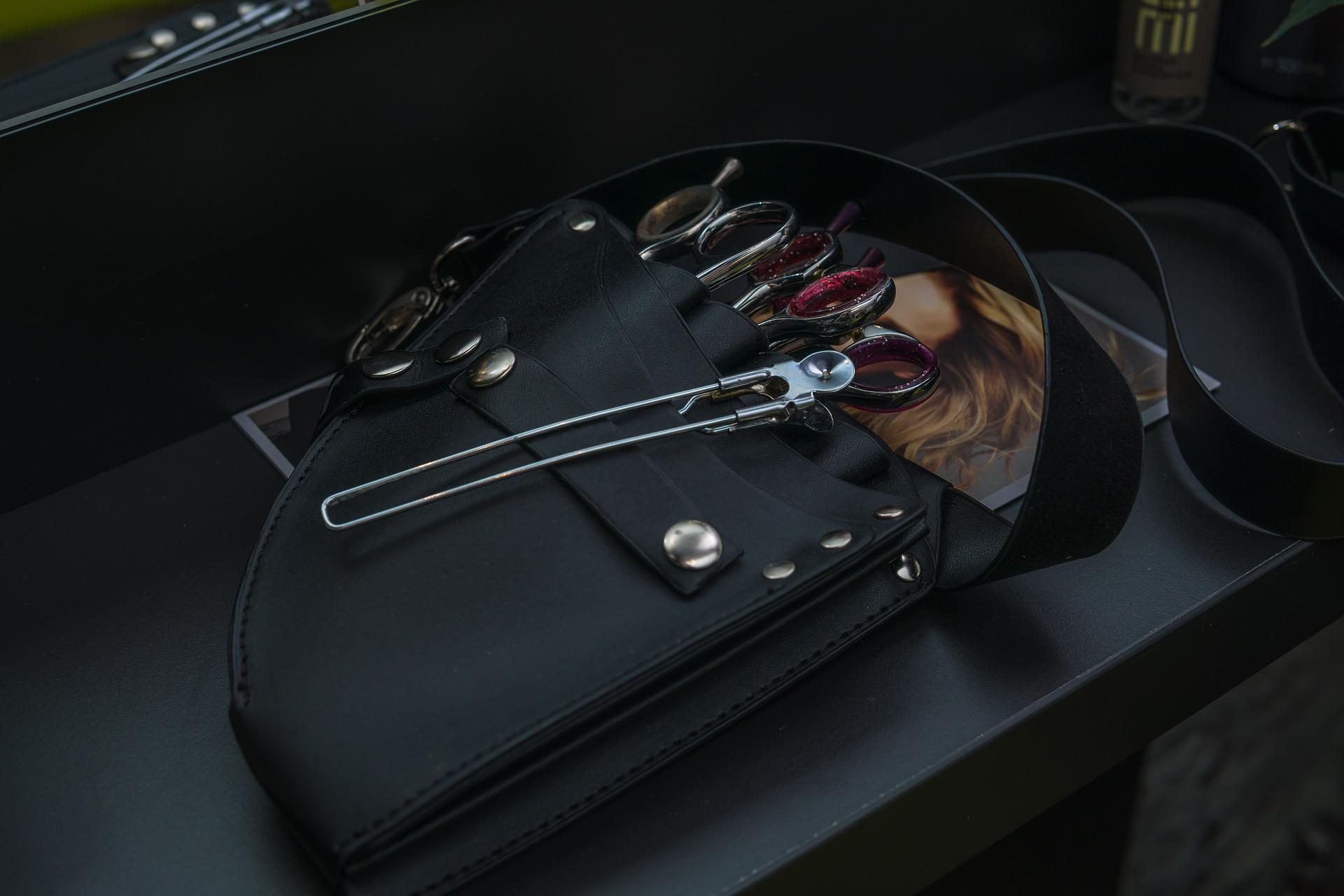 Scheren in der schwarzen Werkzeugtasche auf dem Arbeitsplatz
